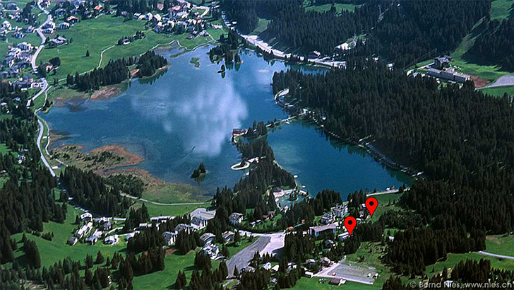 Lenzerheide See aus der Vogelperspektive mit Markierungen für die Ferienwohnungen am See
